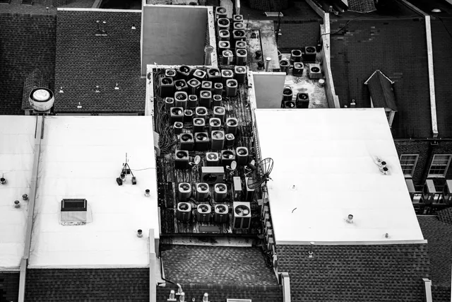 Black-and-white aerial view of New Orleans rooftops lined with air conditioning units